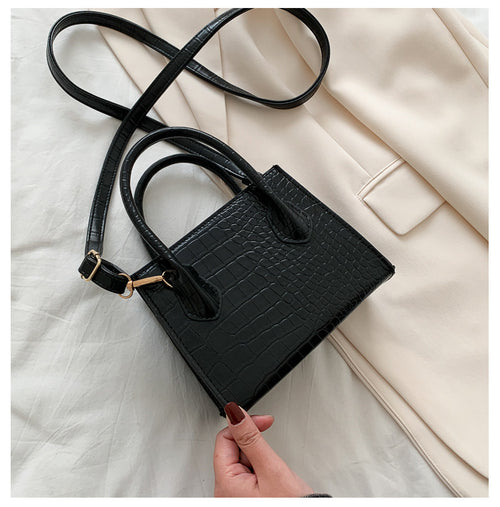 The solid color pattern and crocodile element give this bag a refined, versatile look that pairs with almost any outfit.