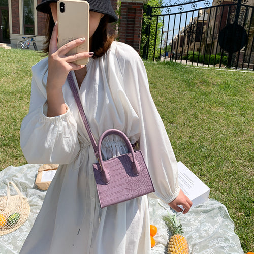The solid color pattern and crocodile element give this bag a refined, versatile look that pairs with almost any outfit.