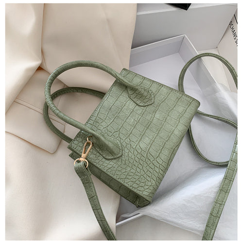 The solid color pattern and crocodile element give this bag a refined, versatile look that pairs with almost any outfit.