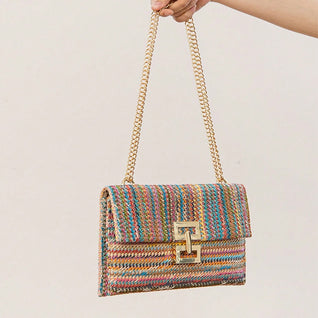 The woven straw design with chain and lock details brings an instant vacation aesthetic to your everyday look.