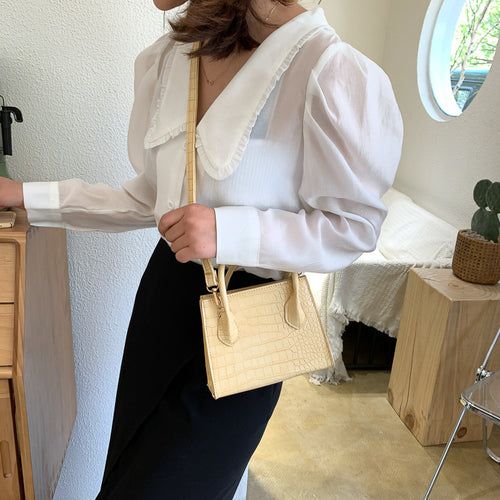 The solid color pattern and crocodile element give this bag a refined, versatile look that pairs with almost any outfit.