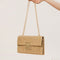 The woven straw design with chain and lock details brings an instant vacation aesthetic to your everyday look.