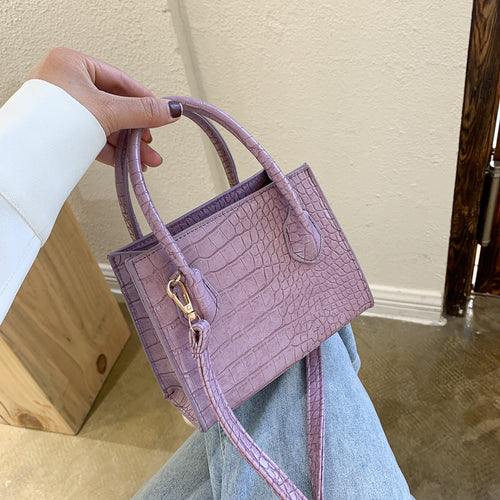 The solid color pattern and crocodile element give this bag a refined, versatile look that pairs with almost any outfit.